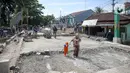Warga melintas di dekat pembangunan revitalisasi Jembatan Cibubur, Jakarta, Senin (24/10/2022). Jembatan Cibubur yang saat ini sedang direvitalisasi, akan dilengkapi akses untuk pejalan kaki. Jembatan Cibubur yang menghubungkan Pasar Rebo dan Ciracas itu akan ditinggikan guna menghindari genangan ketika permukaan Kali Cipinang meninggi dan ditargetkan selesai pada bulan November 2022. (Liputan6.com/Faizal Fanani)