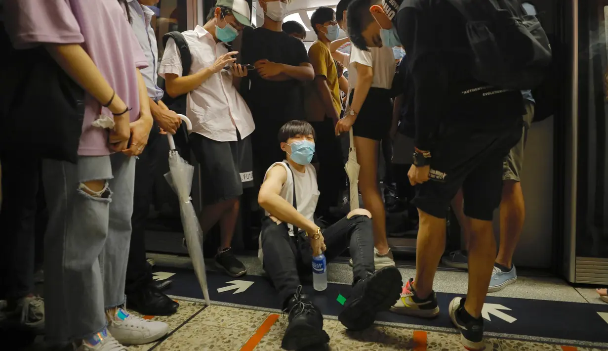 Para pengunjuk rasa memblokir pintu masuk kereta bawah tanah di Hong Kong, Selasa (30/7/2019). Pengunjuk rasa telah mengganggu layanan kereta bawah tanah pada pagi hari perjalanan dengan menghalangi pintu-pintu masuk kereta dan mencegah mereka meninggalkan stasiun. (AP Photo/Vincent Yu)
