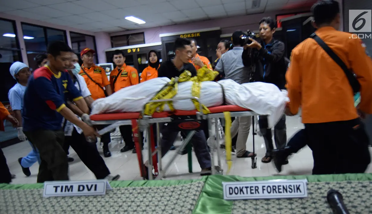 Petugas membawa jenazah korban jatuh helikopter Basarnas di RS Bhayangkara Semarang (3/7). Delapan jenazah tersebut tiba di rumah sakit di Semarang secara bergiliran pada Senin (3/7/2017) dini hari. (Liputan6.com/Gholib)