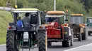 Traktor milik peternak sapi perah berjalan menuju jalan tol atau jalan bebas hambatan untuk melakukan aksi protes di Battice, Belgia, Kamis (30/7/2015). Aksi protes tersebut berkaitan dengan rendahnya harga jual susu. (REUTERS/Francois Lenoir)