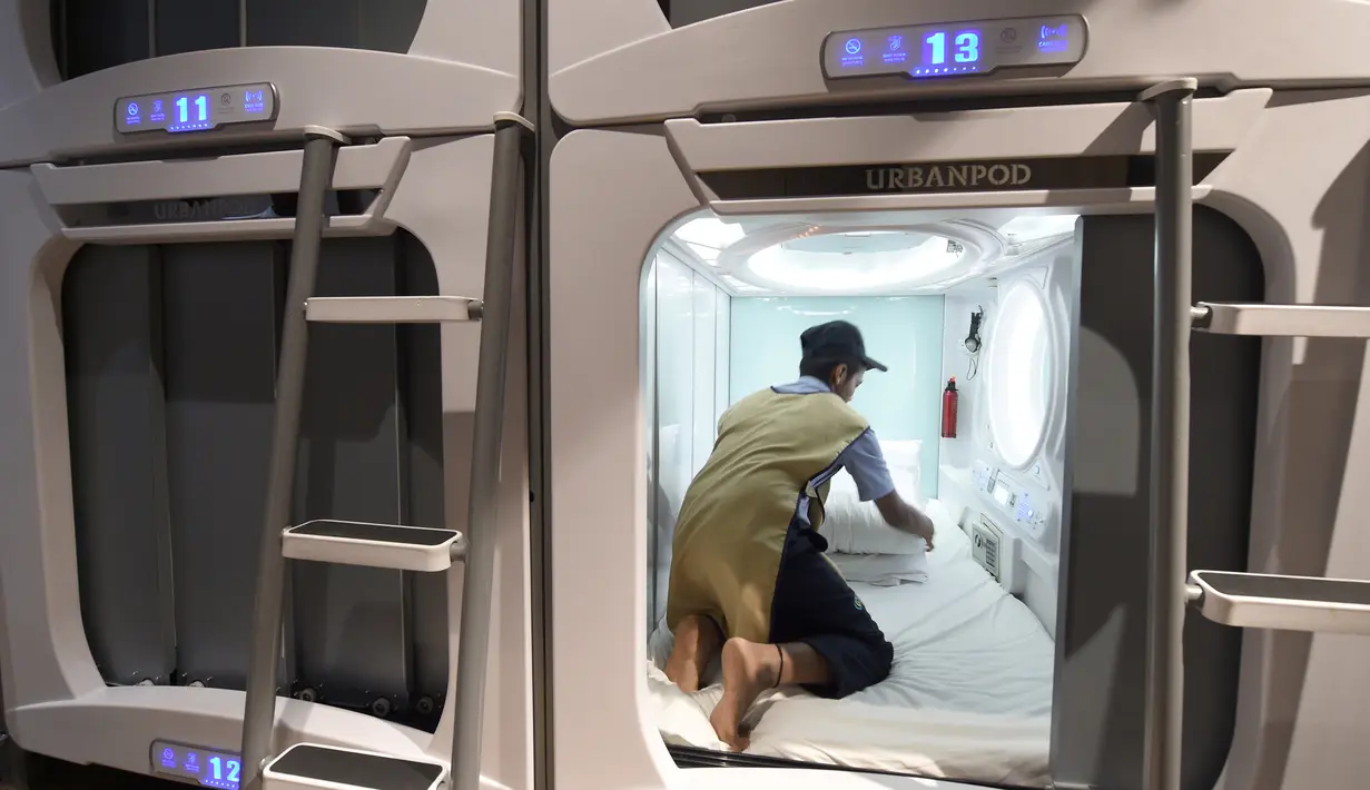 Seorang petugas membersihkan kamar Hotel Urbanpod di Mumbai, India (14/4). Urbanpod ini menyediakan 140 ruangan dengan berbagai macam kategori, seperti Suite Pods, Private Pods, dan exclusive Pods. (AFP/Indranil Mukherjee)