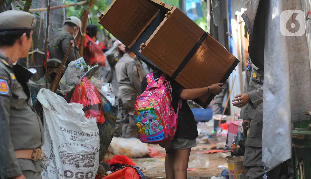 Warga memindahkan barang-barang saat bangunannya terdampak proyek sodetan Ciliwung menuju Kanal Banjir Timur (KBT) di Kelurahan Cipinang Besar Selatan, Jakarta, Kamis (12/1/2023). Pemprov DKI mempercepat pembangunan sodetan kali Ciliwung menuju Kanal Banjir Timur (KBT) dengan tujuan mampu mengurangi dampak banjir dengan volume 60 kubik per detik. (merdeka.com/Imam Buhori)