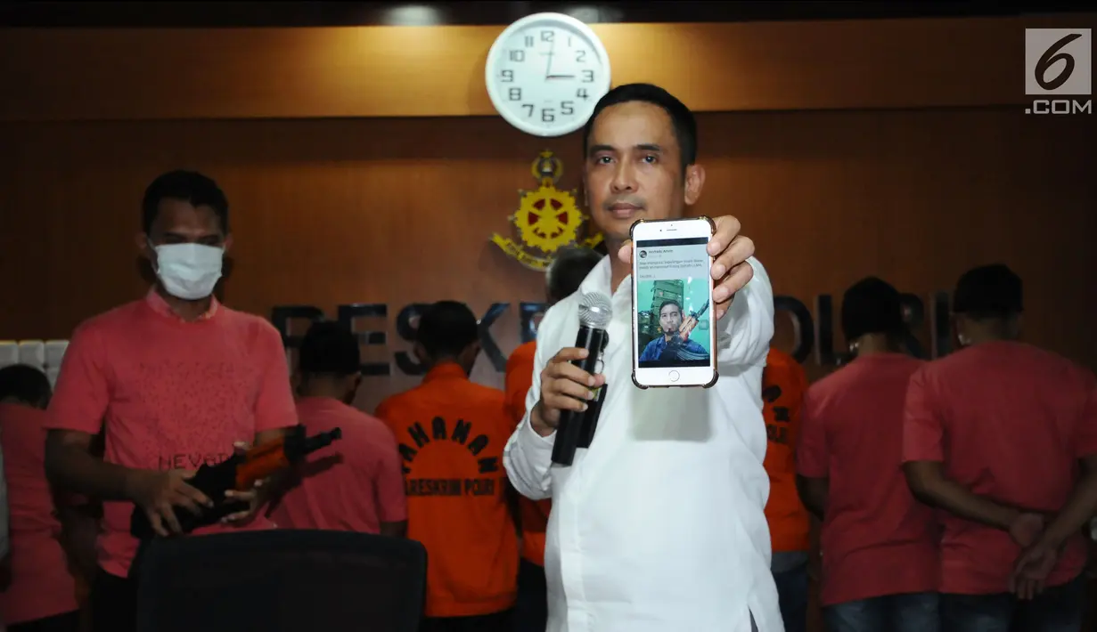 Kasubdit I Dittipid Siber Bareskrim Polri Kombes Pol Irwan Anwar menunjukkan foto berikut tersangka kejahatan siber saat rilis di Jakarta, Rabu (21/2). Dittipid Siber Bareskrim Polri menahan 18 tersangka penyebaran hoax. (Liputan6.com/Helmi Fithriansyah)