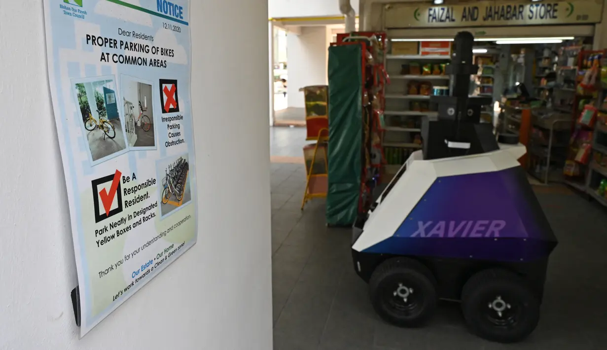 Sebuah robot berpatroli di distrik perbelanjaan dan perumahan selama uji coba oleh Home Team Science and Technology Agency (HTX)  di Singapura, Senin (6/9/2021). Pelanggaran masyarakat akan dicatat dan robot akan mengeluarkan pesan untuk memperingatkan mereka. (ROSLAN RAHMAN/AFP)