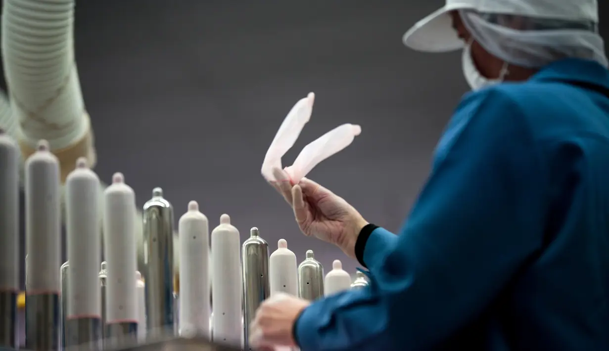 Pekerja memeriksa kualitas kondom di Sagami Rubber Industries, Prefektur Kanagawa, Jepang (25/1). Pada saat itu kondom tertipis sedunia itu dinamakan "Sagami Original 0,01". (AFP Photo/Behrouz Mehri)