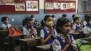 di sebuah sekolah di Mumbai, India, Rabu (15/12/2021). Setelah ditutup selama hampir 20 bulan karena pandemi virus corona, sekolah di Mumbai dibuka kembali untuk kelas 1 sampai 7. (AP Photo/Rafiq Maqbool)