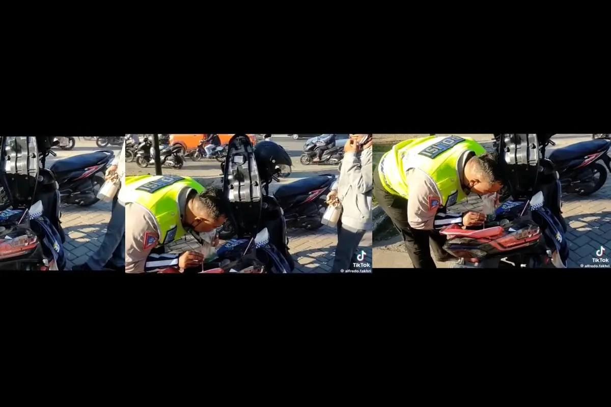 Seorang Polisi Sedot Bensin Motornya Untuk Bantu Pemotor yang Mogok
