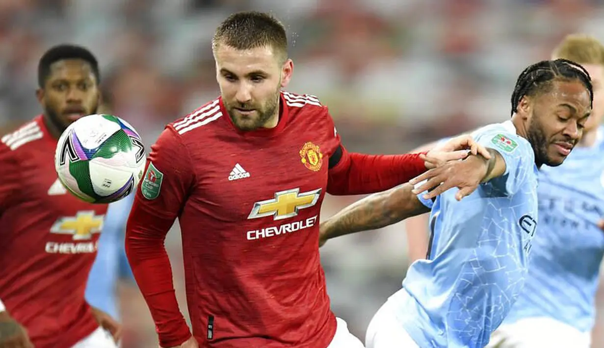 Striker Manchester City, Raheem Sterling, berebut bola dengan pemain bek Manchester United, Luke Shaw, pada laga Piala Liga Inggris di Stadion Old Trafford, Rabu (6/1/2021). City menang dengan skor 2-0. (Peter Powell/Pool via AP)