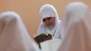 Seorang murid perempuan membaca kitab suci Alquran saat bulan suci Ramadan di sebuah sekolah di Benghazi, Libya, 5 Juli 2015. (REUTERS/Esam Al - Omran Fetori)