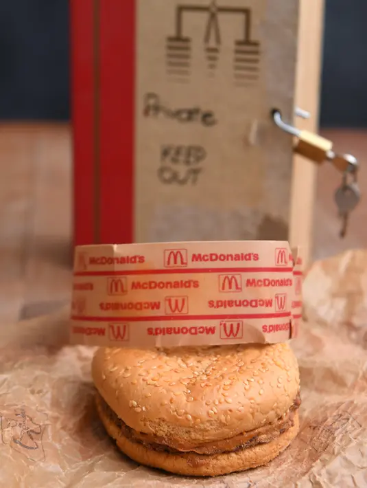 Gambar di Melbourne pada 7 November 2019 memperlihatkan burger McDonald's yang dibeli pada 1995 dan disimpan di gudang Australia selama bertahun-tahun. Bukti burger tersebut benar-benar berasal dari tahun 1995 adalah dari bungkus kemasannya yang hanya ada pada tahun itu. (William WEST/AFP)