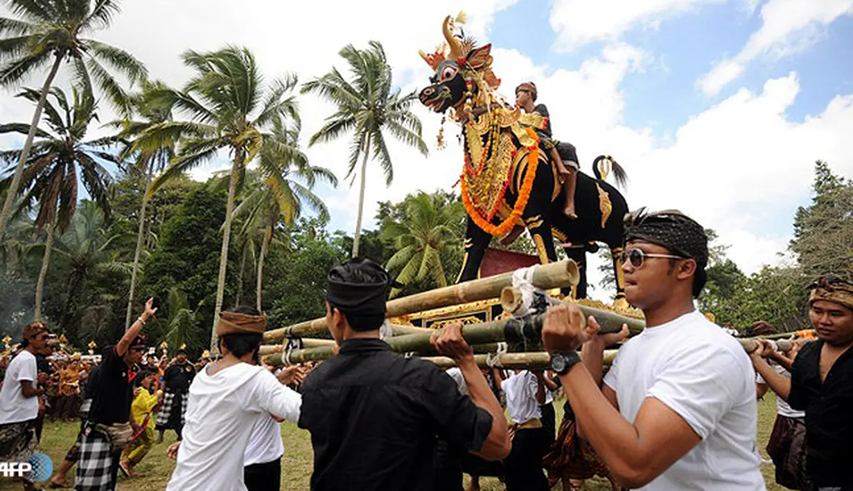 Kaum pria membawa sarkofagus dalam bentuk kerbau  dalam acara ngaben massal di Gianyar, Bali, Indonesia, 02 September 2013. (AFP/Sonny Tumbelaka/wwn)