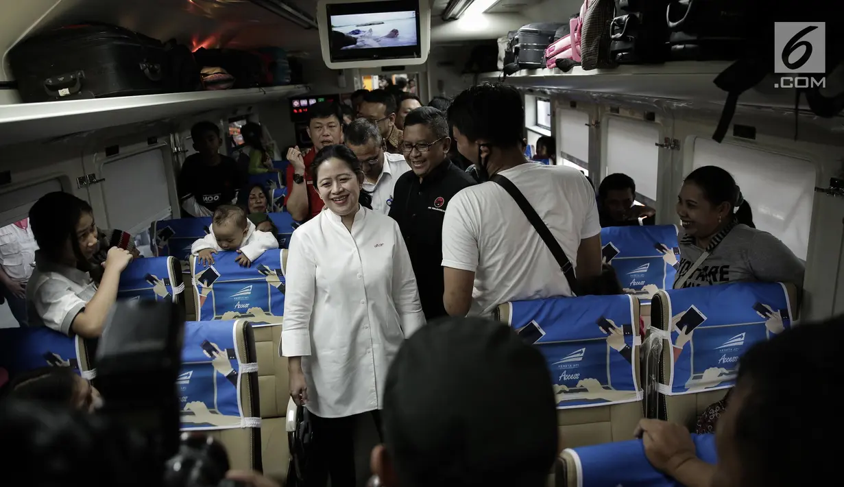 Menko PMK, Puan Maharani berbincang dengan salah satu pemudik di dalam kereta sebelum keberangkatan di Stasiun Senen, Jakarta, Rabu (21/6). Puan juga menggunakan topi kepala stasiun untuk menandai keberangkatan kereta. (Liputan6.com/Faizal Fanani)