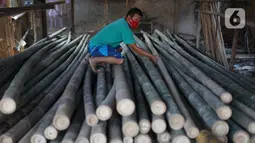 Perajin memilah bambu yang biasa digunakan sebagai tiang bendera di kawasan Manggarai, Jakarta, Kamis (6/8/2020). Adanya pandemi covid-19 menyebabkan penjualan bambu menurun hingga 35% dibanding tahun lalu. (Liputan6.com/Immanuel Antonius)