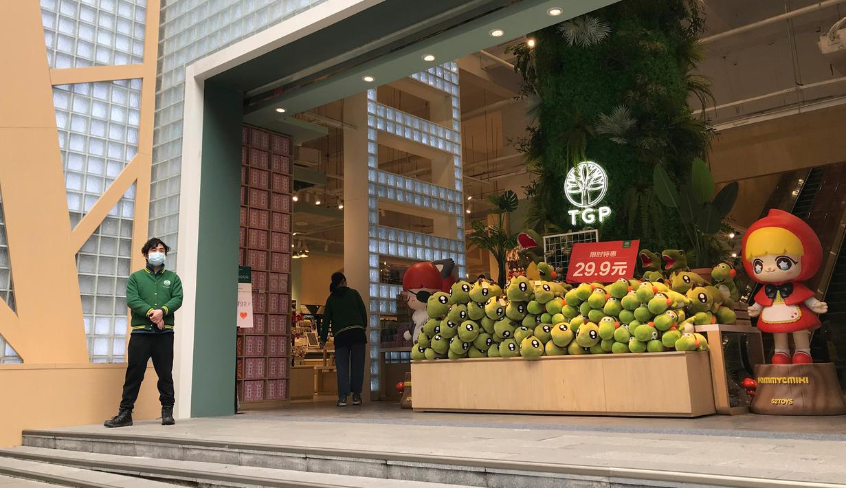 Penjaga toko menunggu pelanggan di sebuah jalan ritel di Wuhan di provinsi Hubei, China tengah (30/3/2020). Para pemilik toko di kota yang menjadi pusat wabah virus corona (Covid-19) itu mulai buka kembali usahanya pada Senin, tapi para pelanggannya masih tampak sepi. (AP Photo/Olivia Zhang)