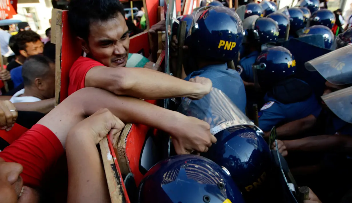 Demonstran berhadapan dengan polisi anti huru-hara ketika aksi protes pada May Day 2016 atau Hari Buruh Sedunia di depan Kedutaan Besar AS di Manila, Filipina, Minggu (1/5). (REUTERS/Czar Dancel)