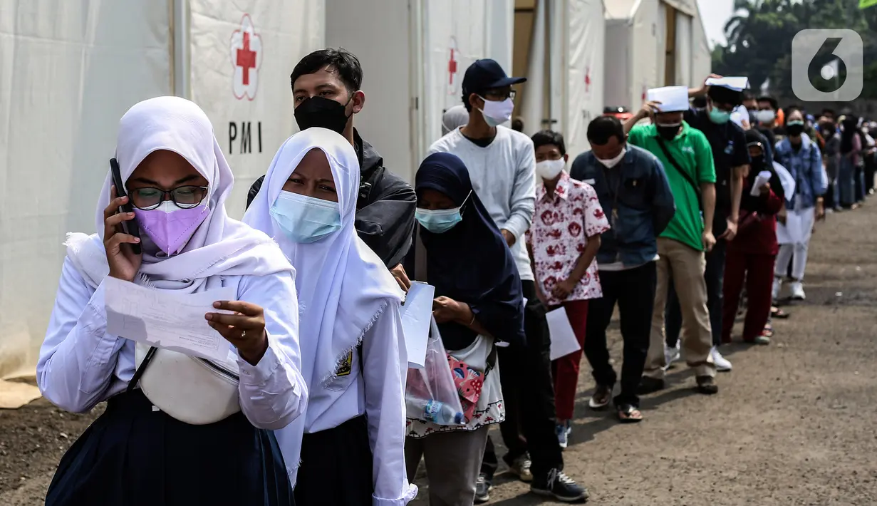 Pelajar dan masyarakat umum antre untuk menerima vaksin covid-19 di Gudang Darurat Nasional Palang Merah Indonesia, Jakarta, Kamis (15/7/2021). Vaksinasi yang menargetkan seribu peserta per hari diselenggarakan hingga 17 Juli 2021. (Liputan6.com/Johan Tallo)