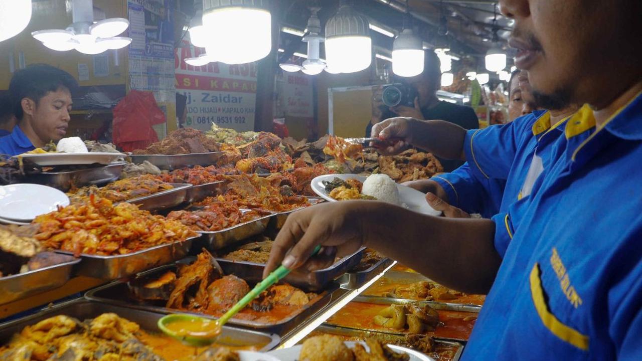 Pengunjung mengambil menu untuk buka puasa di Sentra kuliner Nasi Kapau di Jalan Kramat Raya, Jakarta, Kamis (14/3/2024). Lokasi kuliner yang berada di kawasan Senen ini menjadi tempat favorit para pencinta makanan khas Sumatera Barat. Foto: Liputan6.com