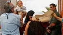 Suasana haru saat sebuah keluarga bertemu di depan gerbang perbatasan Meksiko dan Amerika Serikat ,Tijuana, Meksiko (19/11). Untuk memperingati Hari Anak Sedunia, petugas membolehkan imigran Meksiko bertemu dengan keluarganya. (Reuters/Jorge Duenes)