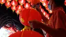 Pekerja dibantu rekannya memasang lampion pemberian umat di Klenteng Boen San Bio, Tangerang, Kamis (28/1/2021). Sebanyak 800  lampion dipasang untuk mempercantik Klenteng jelang perayaan Tahun Baru Imlek. (Liputan6.com/Angga Yuniar)