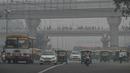 Kendaraan berjalan di sepanjang jalan di tengah kondisi kabut asap tebal di New Delhi (15/11/2021). India memutuskan untuk menutup sekolah di New Delhi selama sepekan dan berencana menerapkan lockdown untuk melindungi warganya. (AFP/Money Sharma)