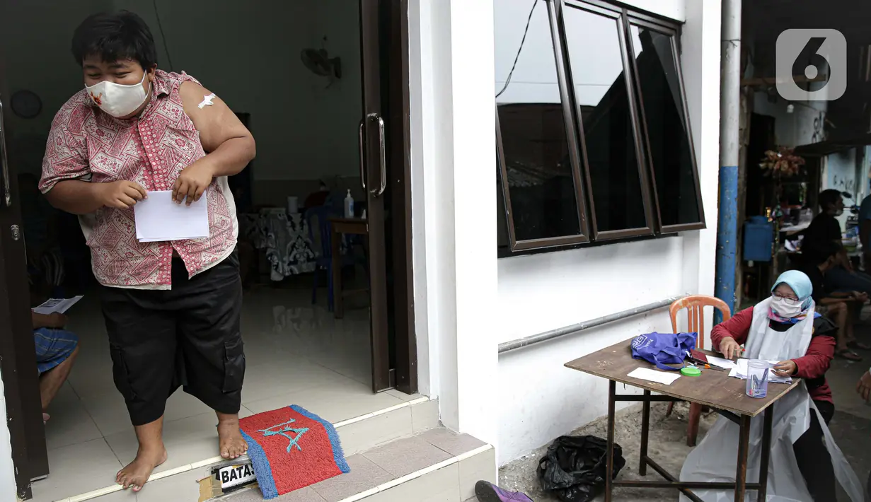 Warga Kebon Pala usai menjalani vaksinasi COVID-19 di Puskemas Kampung Melayu, Jakarta, Jumat (18/6/2021). Presiden Joko Widodo mengingatkan Pemprov DKI Jakarta untuk mengejar target vaksinasi 7,5 juta warga sampai Agustus 2021. (Liputan6.com/Faizal Fanani)