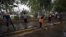 Pekerja kota Irak membersihkan jalanan setelah serangan bom bunuh diri semalam di Syiah Baghdad di al-Shoala (24/5). Empat orang tewas dan beberapa lainnya terluka ketika seorang pembom bunuh diri menyerang kafe di Baghdad. (AFP Photo/Ahmad Al-Rubaye)
