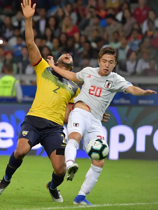 Striker Kashima Antlers, Hiroki Abe berebut bola dengan pemain Ekuador Arturo Mina selama pertandingan Copa America di Stadion Mineirao, Brasil pada 24 Juni 2019. Abe tidak akan masuk ke tim utama Barca. Abe diproyeksikan untuk Barcelona B yang bermain di divisi tiga.  (AFP Photo/Luis Acosta)