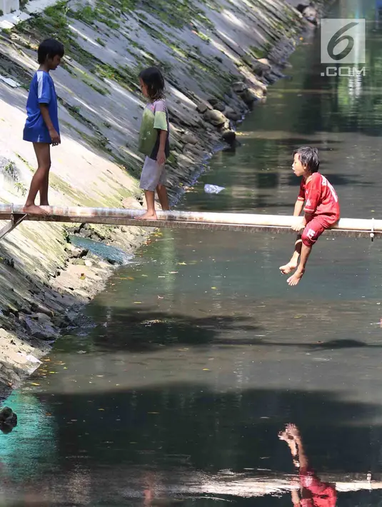 Anak-anak bermain di sungai di Jakarta, Sabtu (7/4). Gubernur DKI Jakarta Anies Baswedan memastikan akan tetap membangun Ruang Terbuka Hijau (RTH). RTH yang dimaksud yakni membangun Taman Maju Bersama dan Taman Pintar. (Liputan6.com/Angga Yuniar)