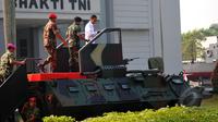 Presiden Joko Widodo saat menaiki Panser Anoa untuk menghadiri upacara pengangkatan dirinya sebagai warga kehormatan pasukan khusus TNI, Kamis (16/4/2015). (Liputan6.com/Yoppy Renato)