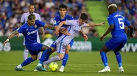 Pemain Barcelona Gavi (tengah) berebut bola dengan pemain Getafe Mathias Olivera (kiri) dan Chema (tengah) pada pertandingan sepak bola La Liga di Stadion Coliseum Alfonso Perez, Getafe, Spanyol, 15 Mei 2022. Pertandingan berakhir imbang 0-0. (AP Photo/Manu Fernandez)