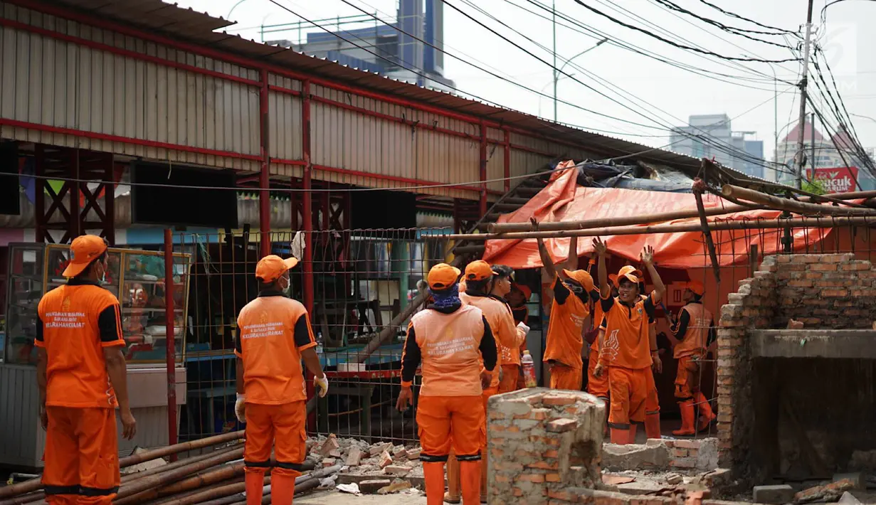 Petugas PPSU membongkar bangunan kios pedagang nasi kapau di Jalan Kramat Raya, Senen, Jakarta, Jumat (6/9/2019). Pembongkaran disebabkan adanya rencana revitalisasi trotoar di jalan tersebut. (Liputan6.com/Immanuel Antonius)