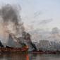 Sebuah kapal besar yang terbakar setelah ledakan besar di pelabuhan Kota Beirut, Lebanon (5/8/2020). Kapal besar tersebut terangkat ke daratan setelah dua ledakan besar menghantam Beirut pada Selasa (4/8/2020) lalu. (AFP Photo)