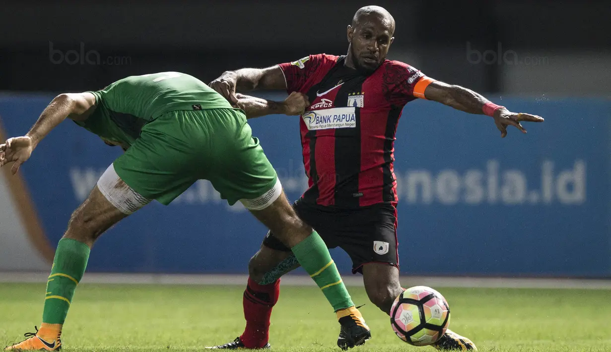 Penyerang Persipura, Boaz Solossa, berebut bola dengan bek Bhayangkara FC, Otavio Dutra, pada laga Liga 1 Indonesia di Stadion Patriot, Bekasi, Sabtu (9/9/2017). Bhayangkara FC menang 2-1 atas Persipura. (Bola.com/Vitalis Yogi Trisna)