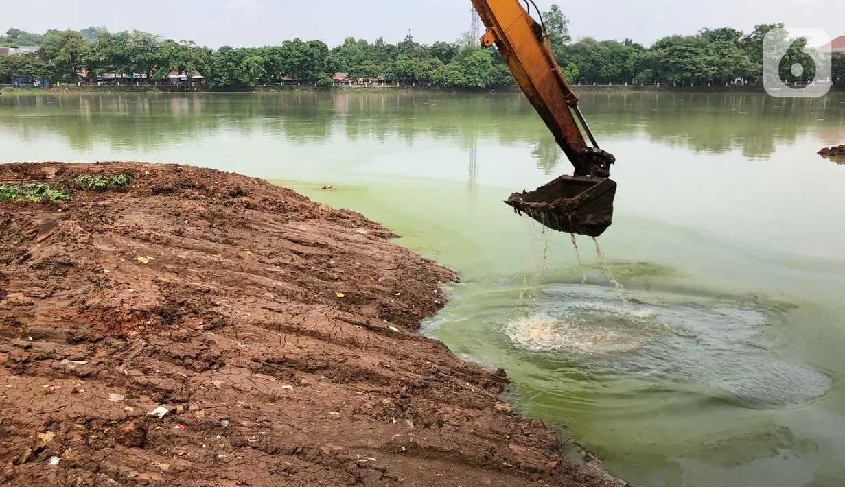 Petugas menggunakan alat berat untuk mengeruk lumpur di kawasan Setu Babakan, Jakarta, Rabu (21/10/2020). Program pengerukan lumpur kali, sungai, atau waduk di Jakarta bertujuan untuk mencegah banjir serta mengantisipasi adanya genangan air saat musim penghujan. (Liputan6.com/Immanuel Antonius)