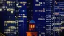 Lampu menyala pada beberapa gedung bank di Frankfurt, Jerman, Kamis (24/9/2020). Di latar depan gereja Paul. (AP Photo/Michael Probst)