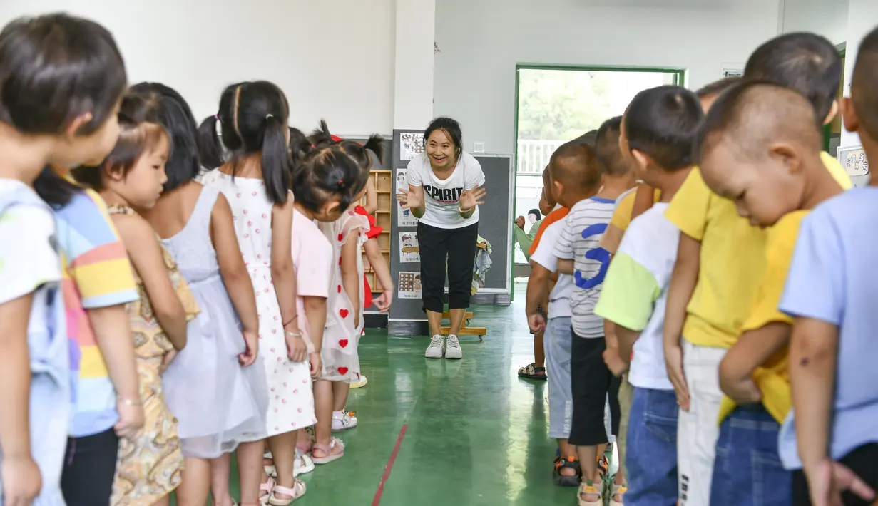 Anak-anak memperkenalkan diri mereka dibantu guru di taman kanak-kanak lokasi relokasi wilayah Sansui, Provinsi Guizhou, China, 31 Agustus 2020. Guizhou melakukan segala upaya untuk membangun atau memperluas 669 sekolah di lokasi relokasi tersebut. (Xinhua/Yang Wenbin)