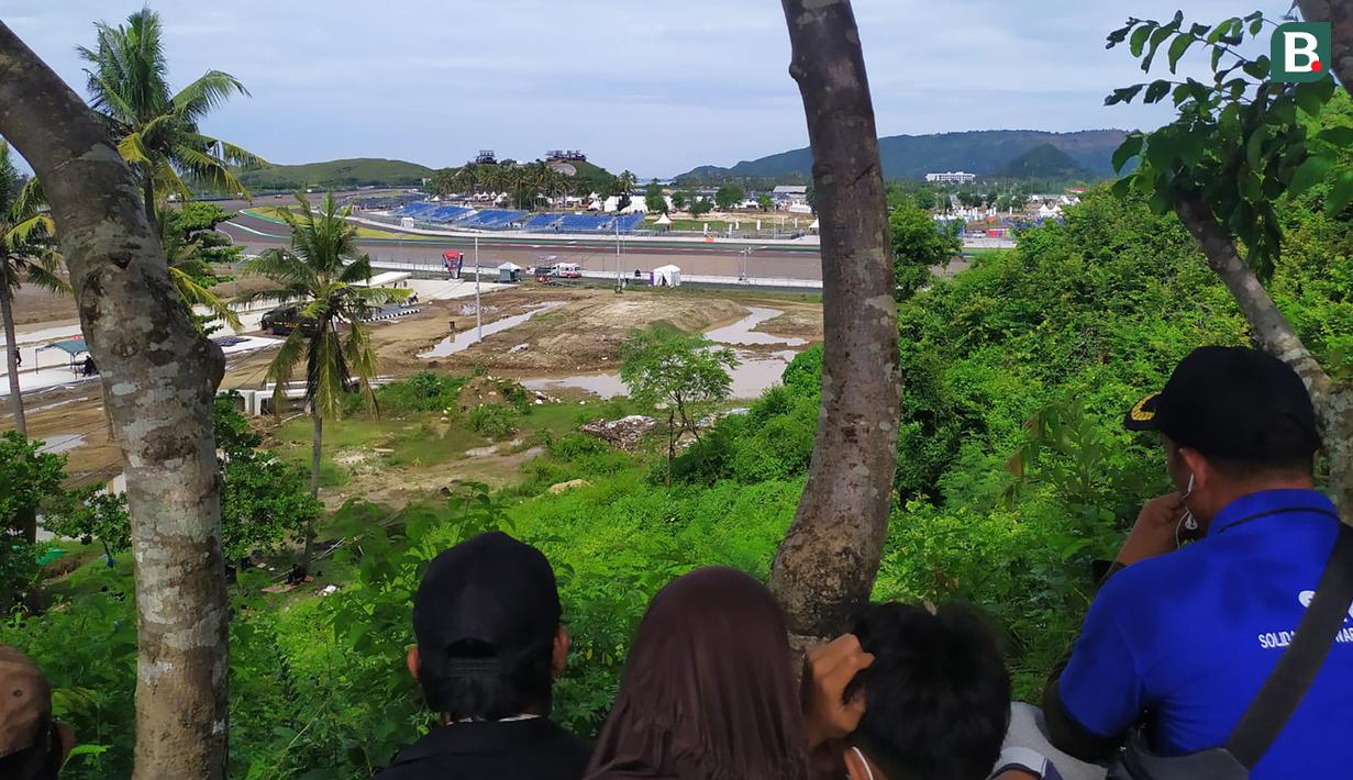 Warga menonton dari Bukit Pongos. (Bola.com/Wiwig Prayugi)