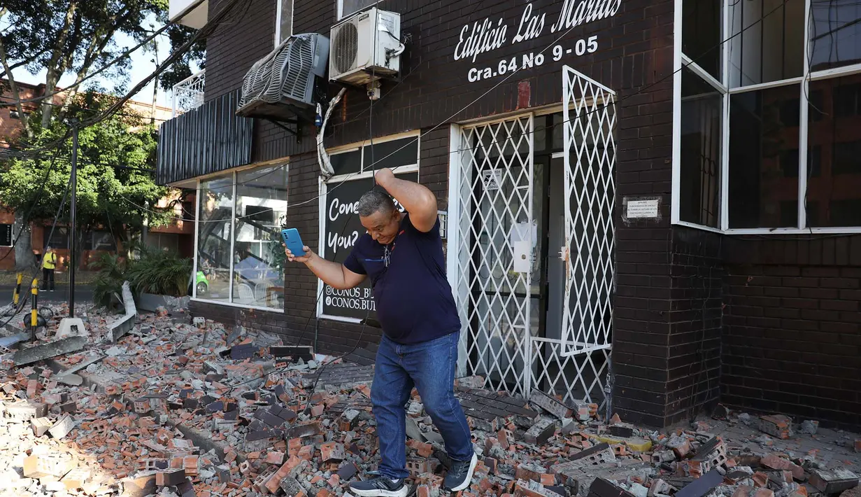 Seorang pria keluar dari gedung apartemen setelah gempa bumi melanda Cali, Kolombia, Senin, 10 Agustus 2026. (Foto AP/Santiago Saldarriaga)