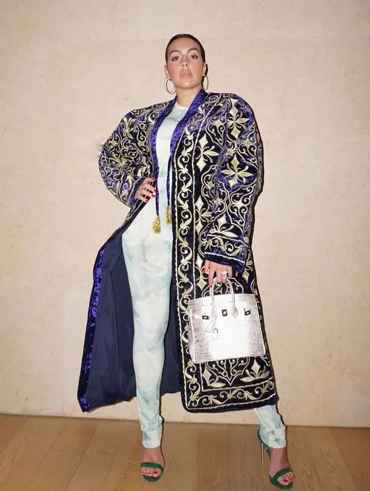 Georgina kenakan bodycon jumpsuit berwarna biru muda di Dubai dipadukan dengan velvet coat dan tas Hermes [instagram/georginagio]