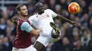 Bek Liverpool, Mamadou Sakho, berebut bola dengan striker West Ham, Andy Carroll, pada laga Liga Premier Inggris di Stadion Boleyn Ground, Inggris, Sabtu (2/1/2016). Liverpool takluk 0-2 dari West Ham. (Reuters/John Sibley)