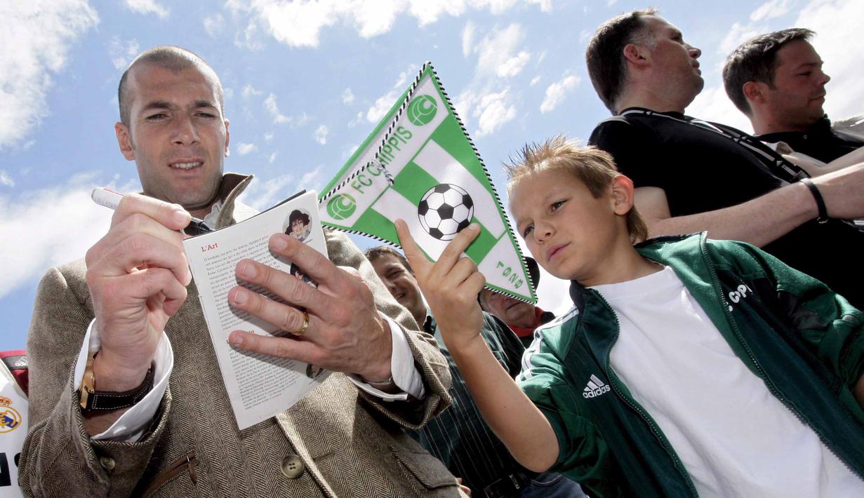  Zinedine Zidane memberikan tanda tangan kepada seorang anak pada laga amal ELA foundation di Saillon, Swiss, Sabtu(02/06/2007). Zidane  ikut kampanye metabolic diseases; penyakit medis yang berkaitan dengan produksi energi. (EPA/Olivier Maire)