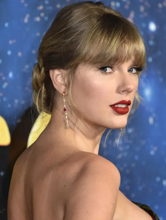 Penyanyi AS Taylor Swift berpose saat tiba menghadiri pemutaran perdana film "Cats" di Alice Tully Hall di New York City (16/12/2019). Di film ini Taylor Swift berperan sebagai penyanyi kucing Bombalurin. (Steven Ferdman/Getty Images/AFP)