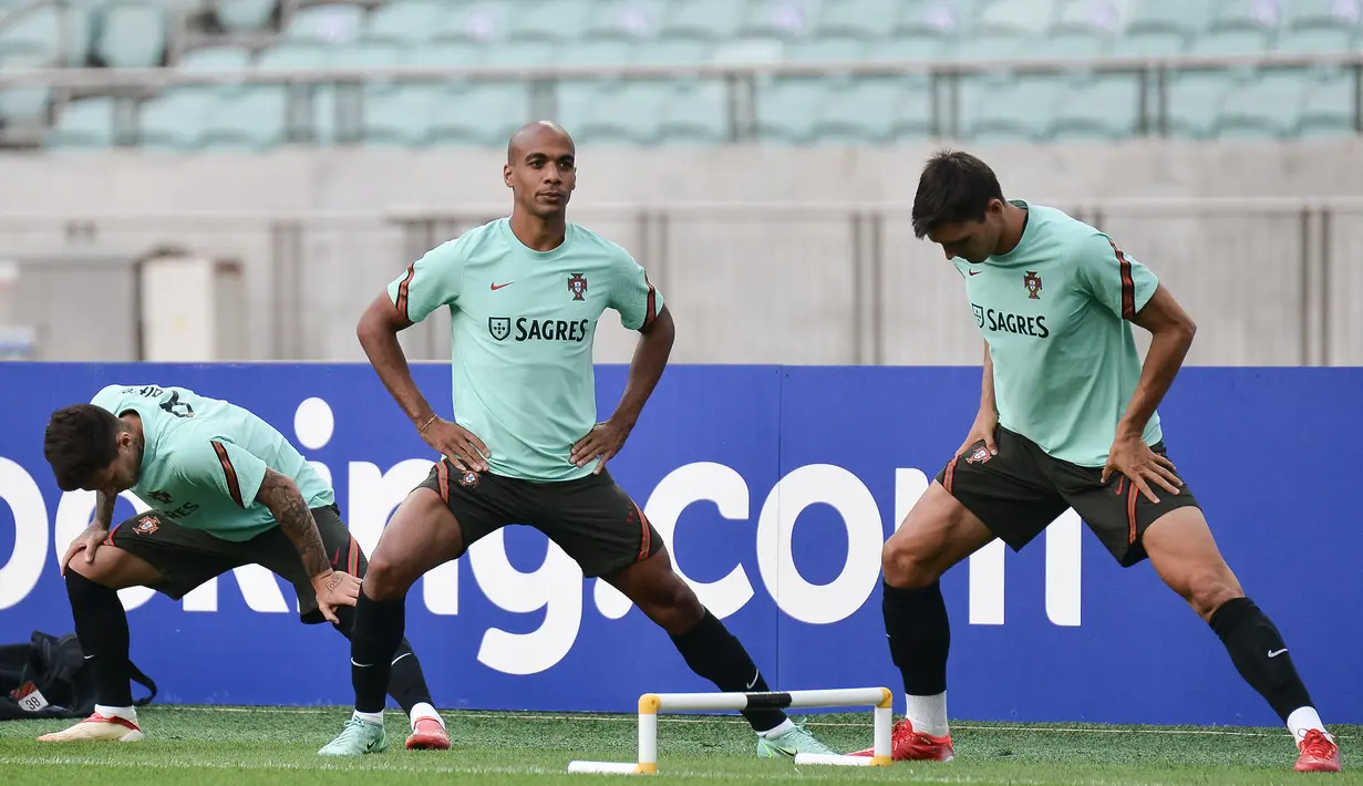 Gelandang Portugal, Joao Mario (tengah) dan rekan satu timnya melakukan pemanasan dalam sesi latihan di Baku (6/9/2021). Dalam laga ini, Cristiano Ronaldo tidak bisa main akibat terkena akumulasi kartu kuning. (AFP/Toflik Babayev)
