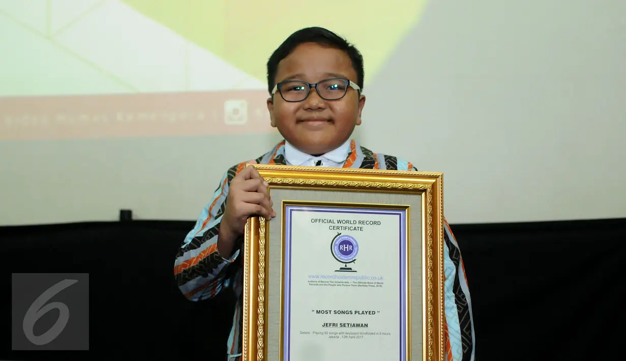 Jefri Setiawan berpose usai menerima penghargaan dari Official World Record di Auditorium Kemenpora, Jakarta, Kamis (14/11). Jefri mencatat rekor dunia baru memainkan 60 lagu menggunakan keyboard dengan mata tertutup. (Liputan6.com/Helmi Fithriansyah)