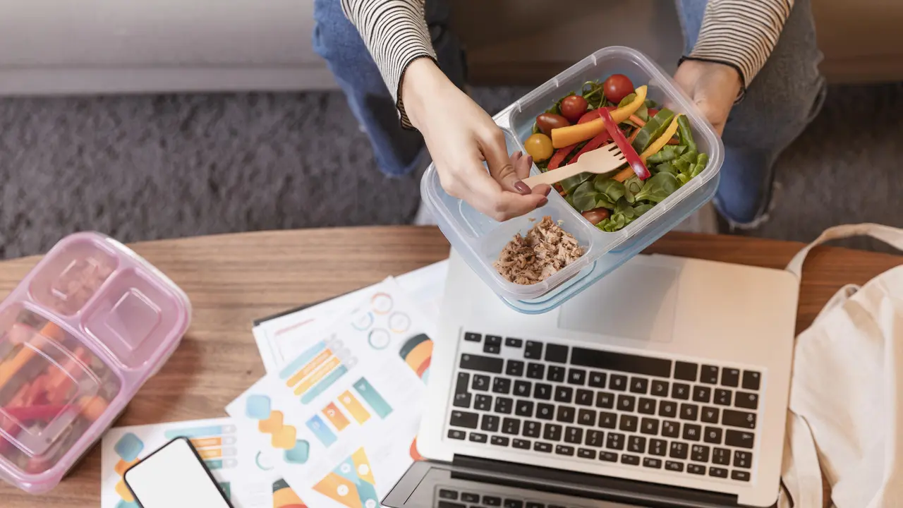 Seorang perempuan memakan bekal makanan di kantor (Foto Dok: Freepik/freepik)
