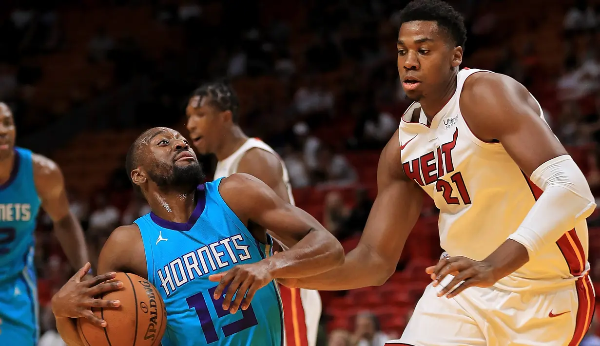 Kemba Walker #15 mencoba melakukan lay up saat diadang pebasket Miami Heat, Hassan Whiteside #21 pada laga NBA pre-season di American Airlines Arena, Miami, (9/10/2017). Miami Heat menang 109-106. (Mike Ehrmann/Getty Images/AFP)