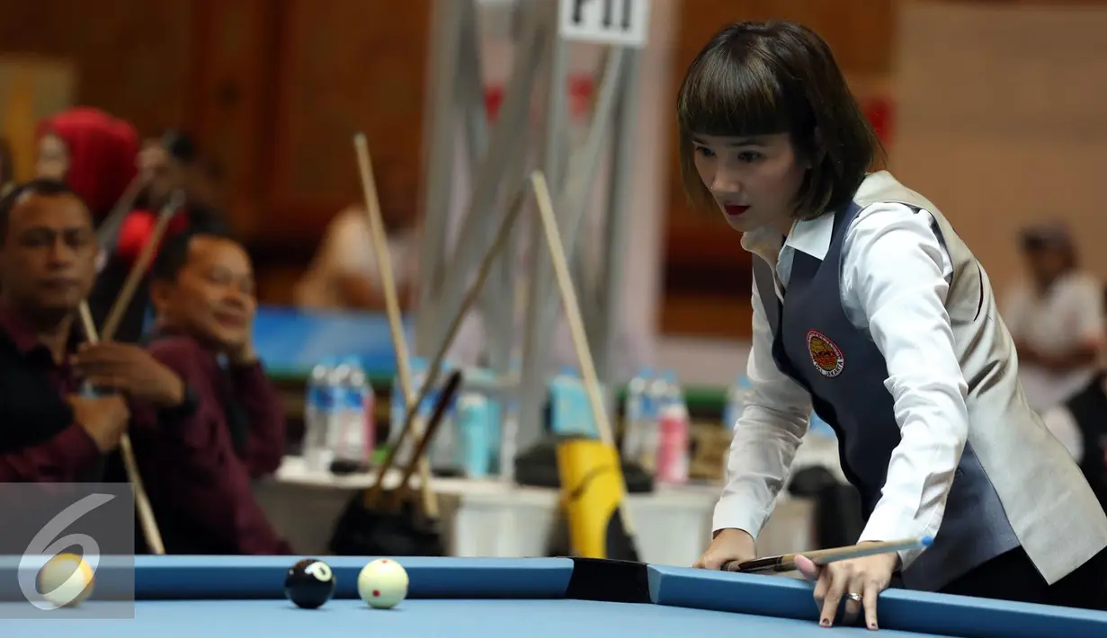Pebiliar putri DKI Jakarta, Angeline M Ticoalu melihat posisi bola saat laga penyisihan 10 ball PON XIX Jabar di Graha Manggala Siliwangi, Bandung, Kamis (22/9). Angeline berhasil mengalahkan pebiliar Papua, Ari S Wati. (Liputan6.com/Helmi Fithriansyah)
