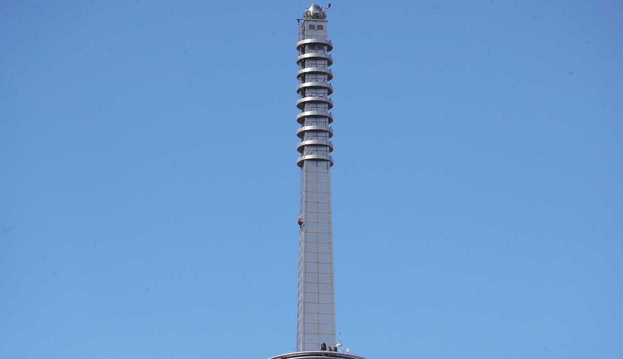 Atlet panjat tebing 'free solo' asal Amerika, Alex Honnold saat memanjat menuju puncak gedung Taipei 101 tanpa tali pengaman di Taipei, Minggu (25/01/2026). (AP Photo/Chiang Ying-ying)