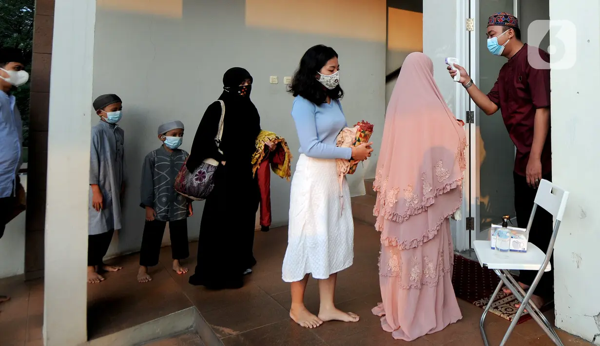 Umat muslim diperiksa suhu tubuhnya saat akan melaksanakan salat Idul Adha 1442 H di Masjid Al-Madina Zona Madina, Parung, Bogor, Jawa Barat, Selasa (20/7/2021). Protokol kesehatan yang dilakukan di antaranya pengecekan suhu tubuh dan pengaturan jarak shaf salat. (merdeka.com/Arie Basuki)