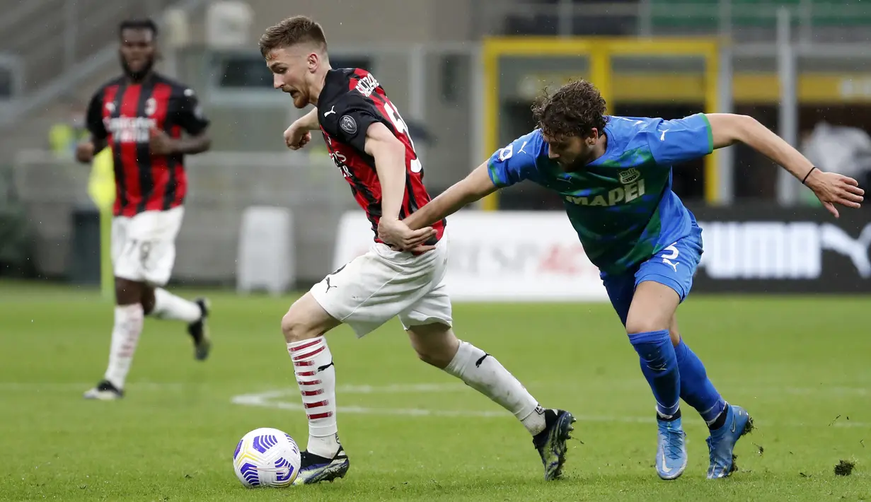 Striker AC Milan, Alexis Saelemaekers (kiri) menguasai bola dibayangi bek Sassuolo, Federico Peluso dalam laga lanjutan Liga Italia 2020/2021 pekan ke-32 di San Siro Stadium, Milan, Rabu (21/4/2021). AC Milan kalah 1-2 dari Sassuolo. (AP/Antonio Calanni)